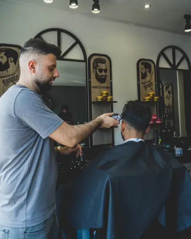 Matay knipt een klant met de tondeuse bij Matay's Barbershop Enschede