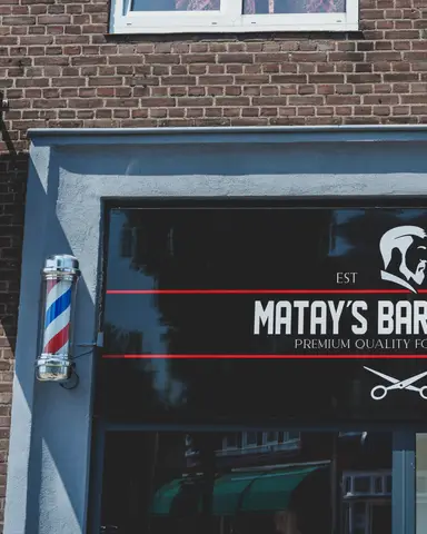 Gevel van Matay's Barbershop in Enschede met barberspaal