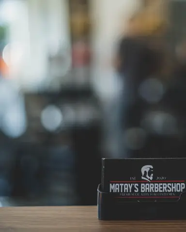 Visitekaarten van Matay's Barbershop op de balie
