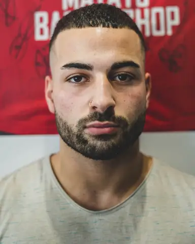 Strakke buzzcut met verzorgde baard, vooraanzicht